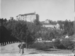 Hrad Český Šternberk od železničního přejezdu, usilnice pod hradem, vpopředí žena nesoucí hrábě negativ 13 x 18
