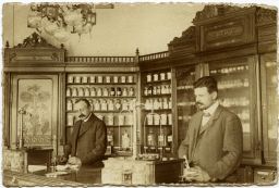 V lékárně, kolem 1900, fotopohlednice