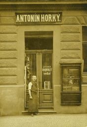 Sedlář Antonín Horký před svou provozovnou, kolem 1908, 166 x 120 mm